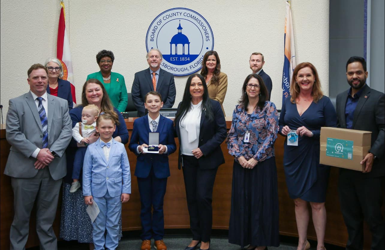 Donna with families and county leaders honoring community heroes at the Board of County Commissioners