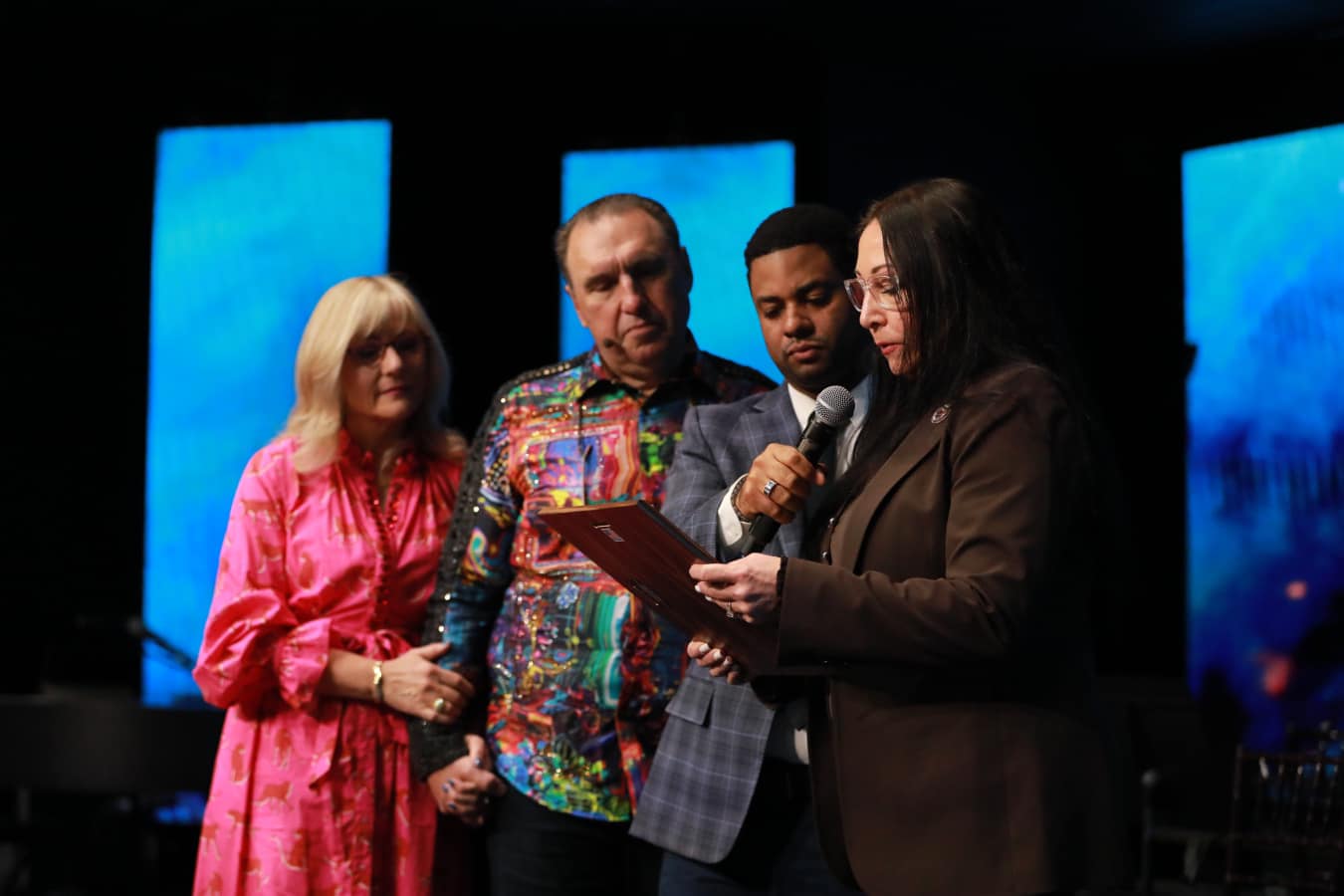 Donna presenting a proclamation on stage at a community event