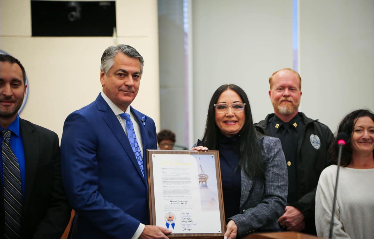 Donna presenting a Human Trafficking Awareness Month proclamation with local law enforcement