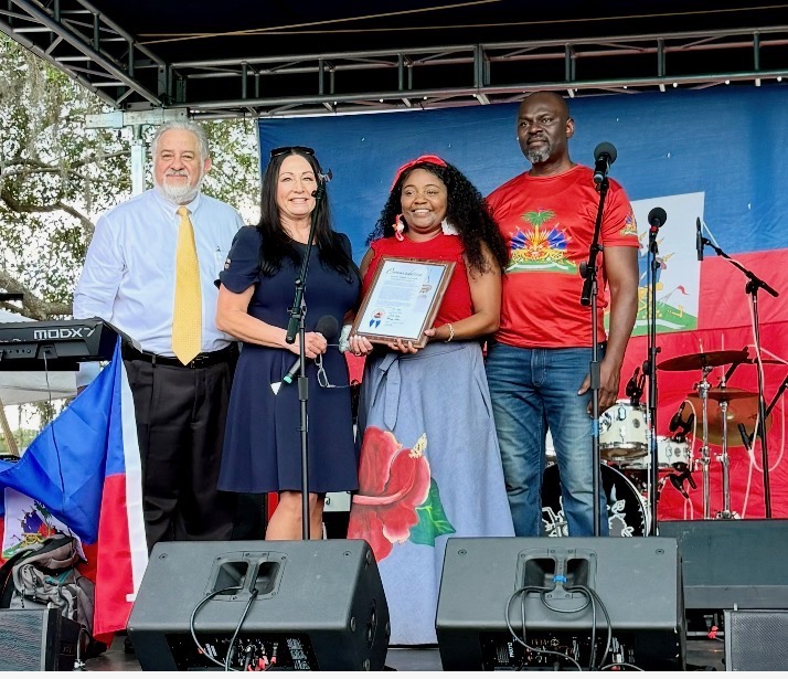 Donna presenting a proclamation on stage at a community festival